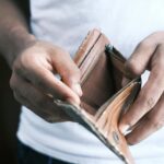Close-up of hands holding an empty wallet, highlighting financial struggles and economic crisis.